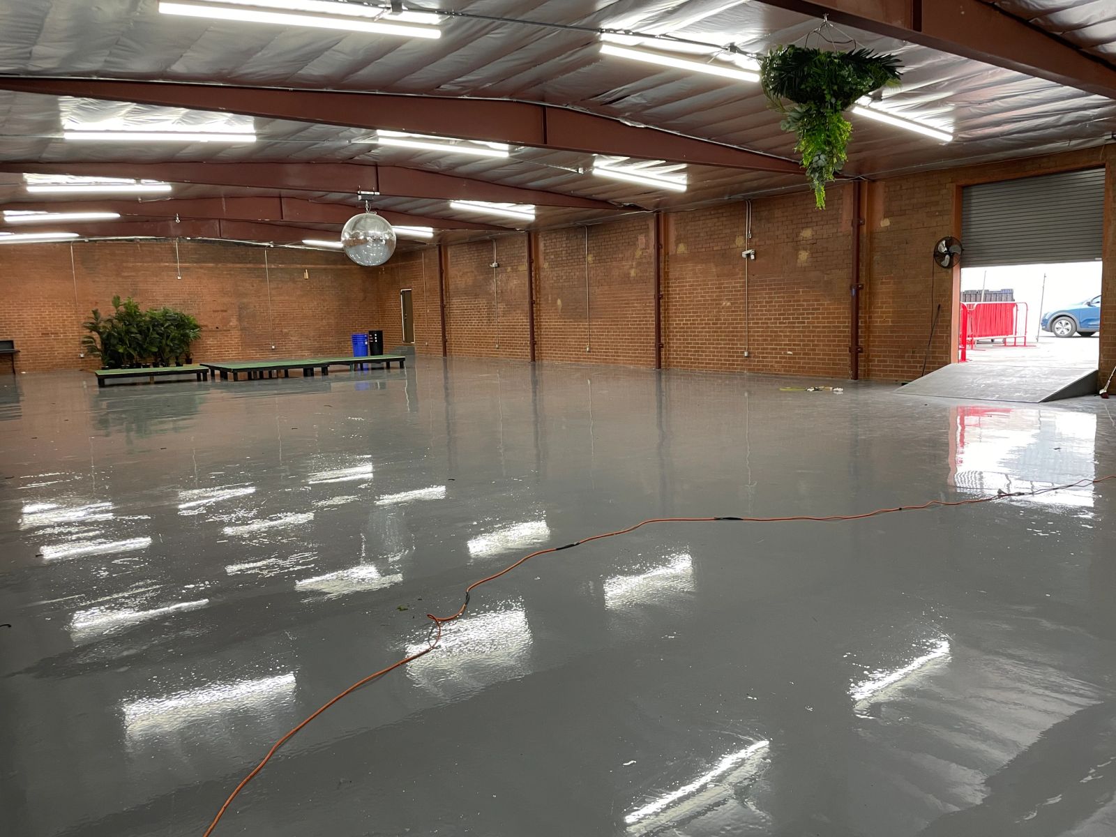 Open warehouse from our existing spaces with brick walls and a roll-up entrance